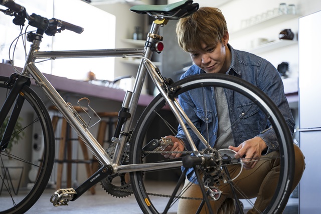 趣味の部屋でロードバイクのメンテナンスを行う男性