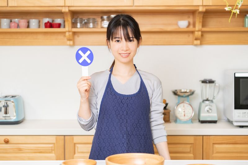 バツのプラカードを持つ女性