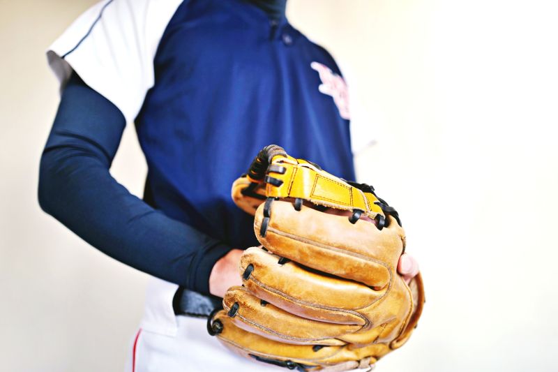 グローブを手にはめている男性