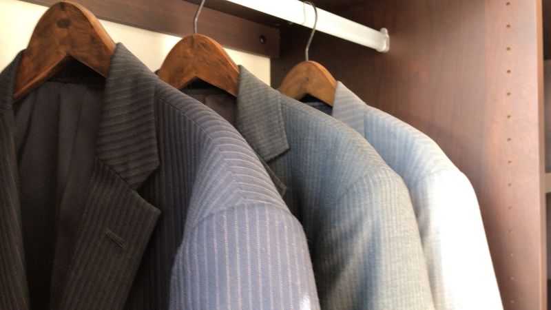 クローゼットに収納された多数のスーツ