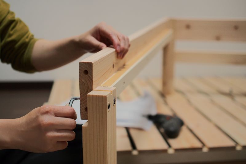 ベッドを解体しようとしている男性の手