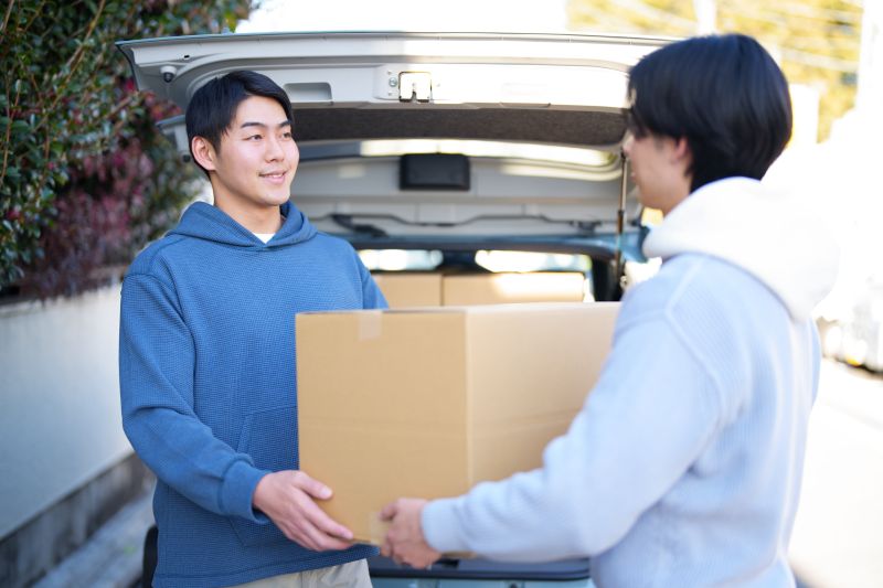 段ボールを運んでいる2人の男性