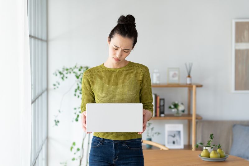 白い箱を両手で持って困っている女性