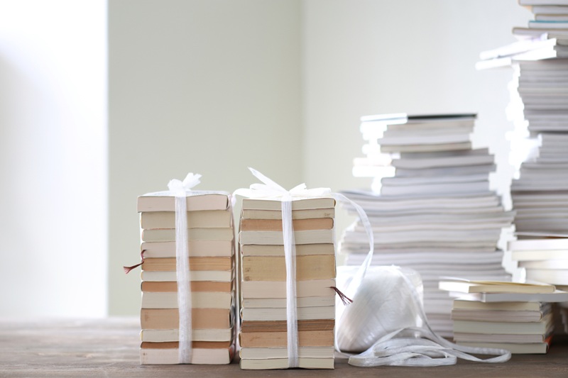 荷造り用の紐で束ねられた本と積み重ねたられた本の山