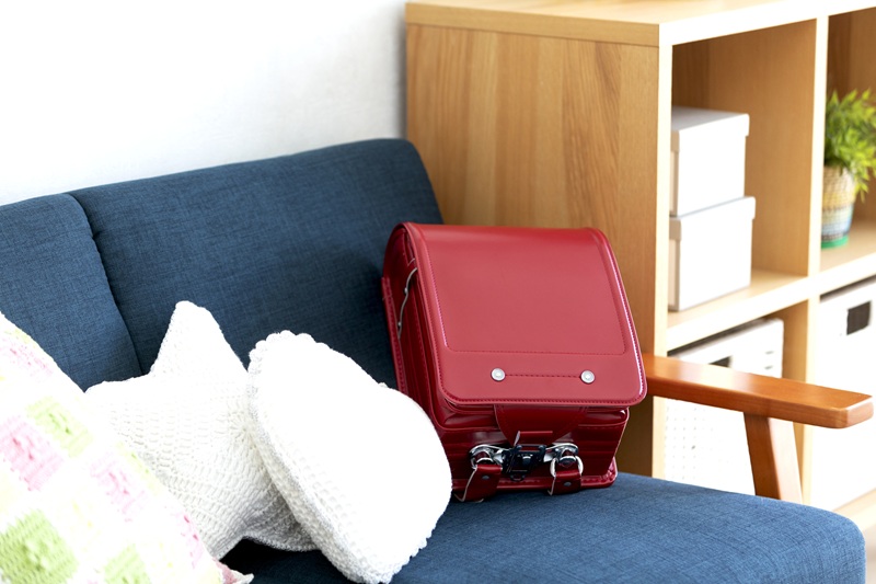家のソファーの上に置かれた赤いランドセル