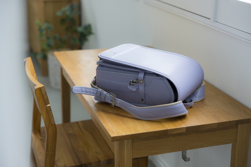 木の机の上に置かれた紫色のランドセル