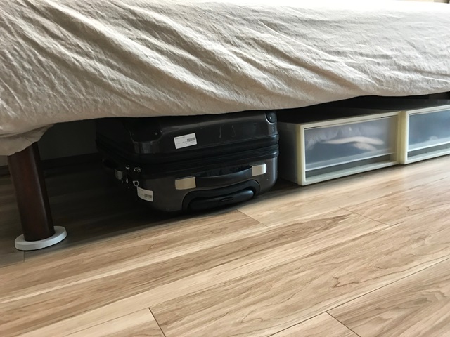 スーツケースをベッドの下に収納する